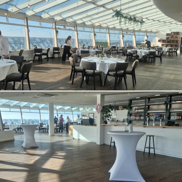 Interieur van de locatie op De Pier: een lichte ruimte met glazen dak, grote ramen met zeezicht en een bar.